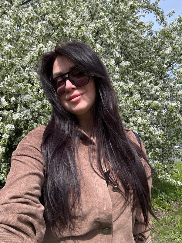 Woman walks husky near blooming trees in Russian urban area