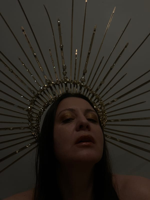 Person in golden crown photographed in elaborate portrait session