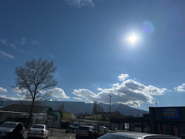 Urban landscape with parking, plants, mountains documented April 7