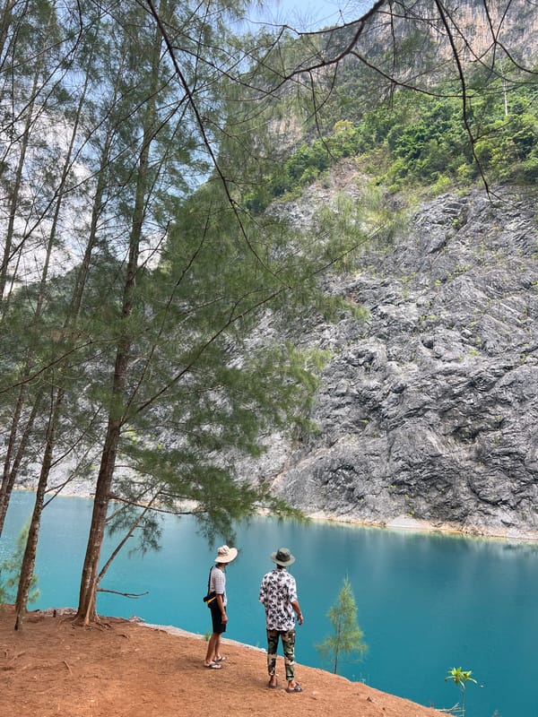 Visitors view blue waters from cliff overlook in Ban Nai Wang