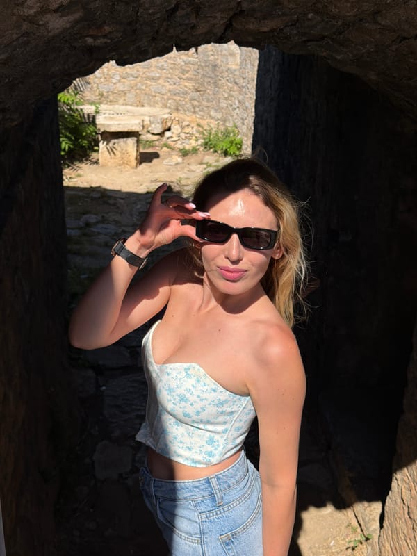 Tourist poses in historic stone archways in Seoce Montenegro