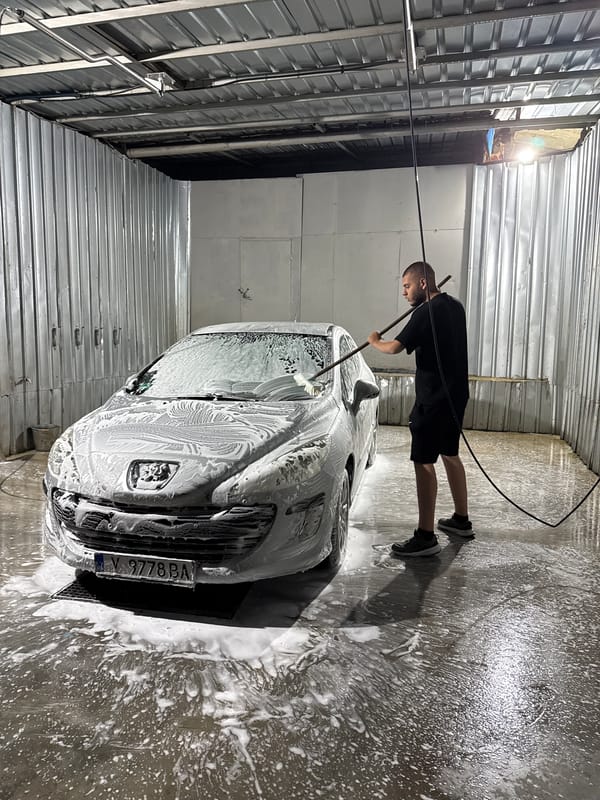 Man washes car at nighttime facility in Elhovo, Bulgaria
