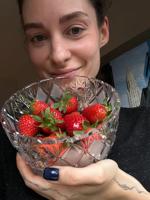 Person photographs strawberry and candy arrangement in crystal bowls