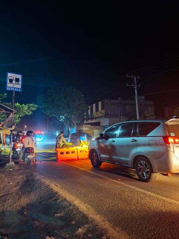 Vehicle parked on wet road in Lhokseumawe, Indonesia
