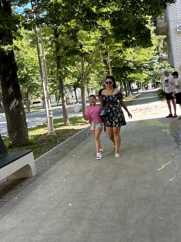 Sunny morning foot traffic along Gelendzhik's tree-lined streets