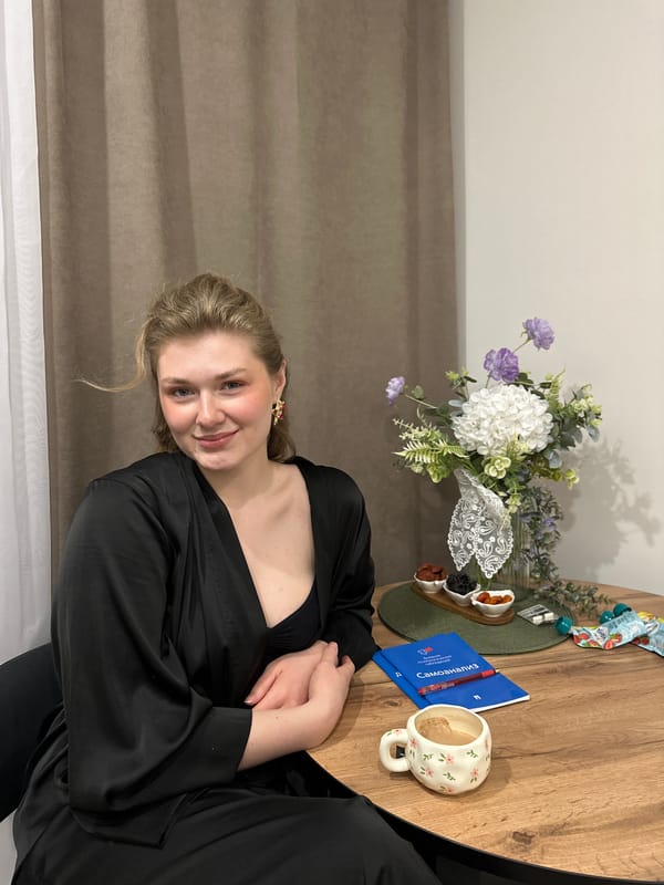 Woman at table with flowers, documents, and snacks