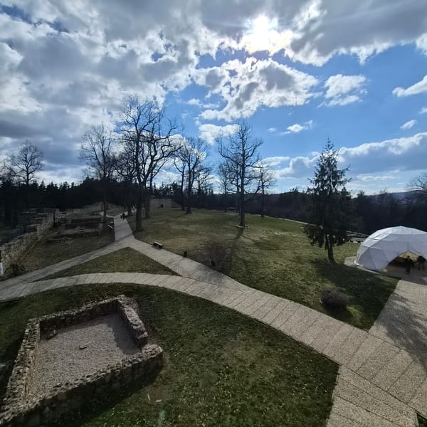 Visitor documents historical ruins and museum displays in Belchin