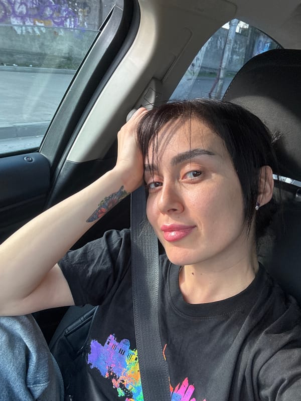 Woman rests in passenger seat during car ride in Tbilisi