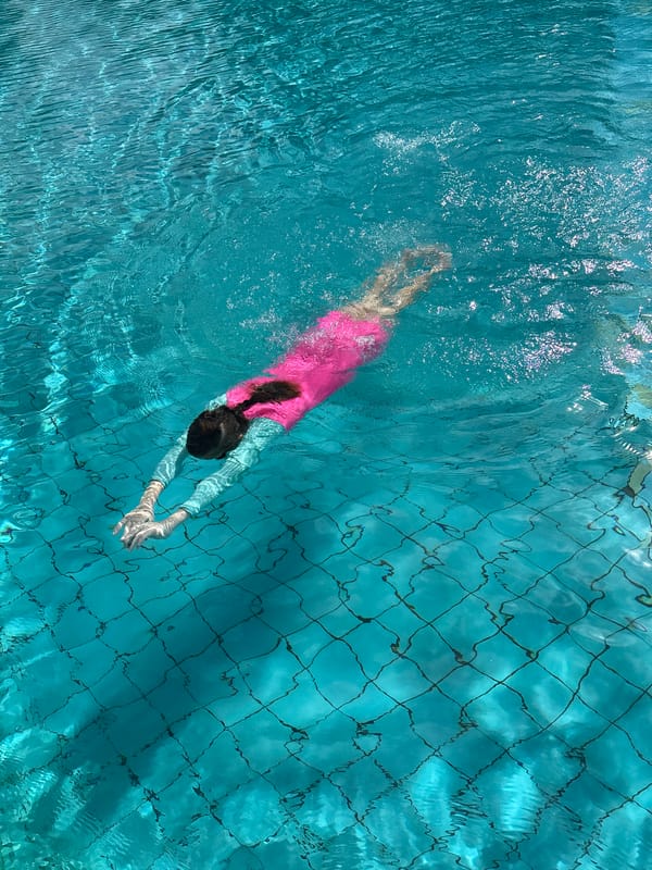 Children swim at Chalong resort pool during early morning hours
