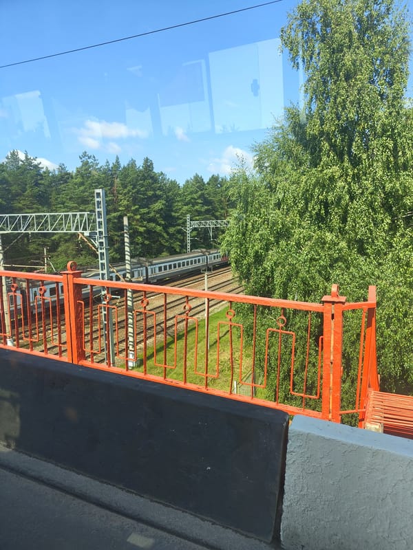 Trains and buses moving through Ramenskoye on a July morning
