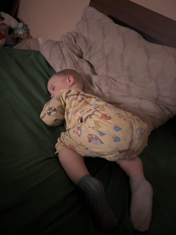 Child in cartoon pajamas rests on bed in Sofia