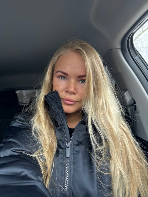 Blonde woman in black coat spotted in car with sunroof