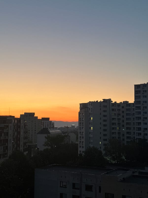 Twilight documented over Sofia apartment buildings with crescent moon visible