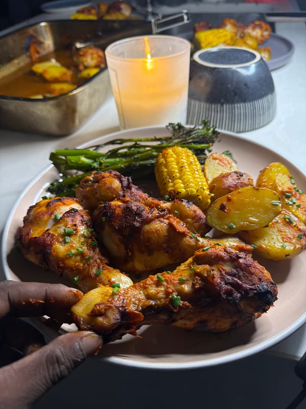 Hand reaches for chicken drumstick at dinner