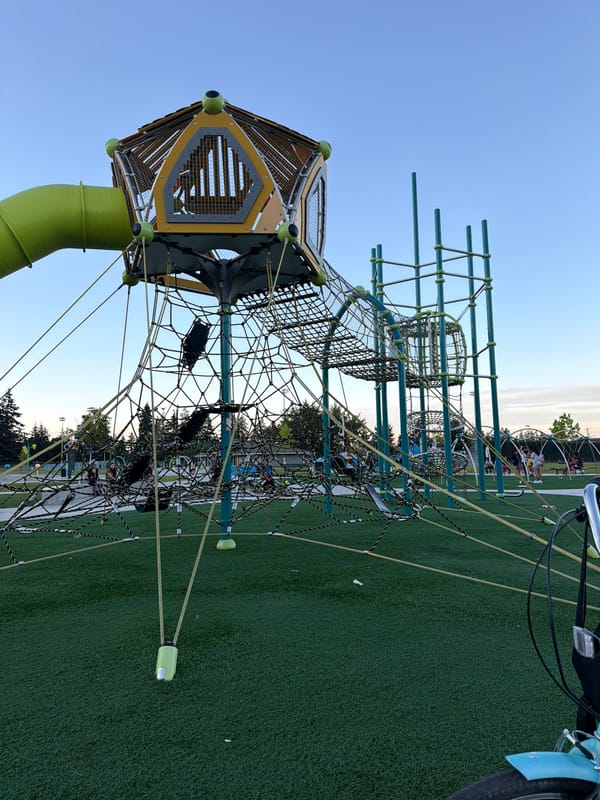 Playground and parked bicycle at an artificial turf recreational spot