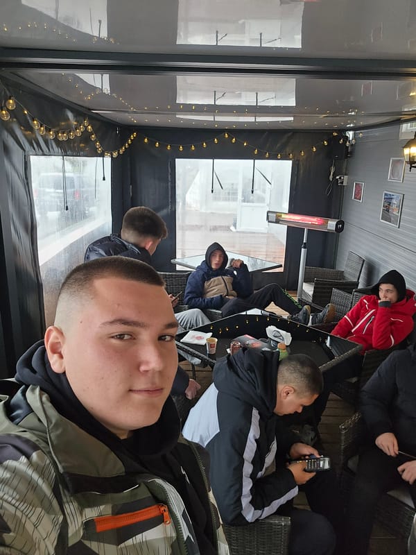 Outdoor cafe operates with heaters during rainy weather
