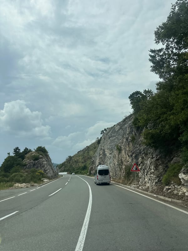 White camper van travels mountain road in Montenegro