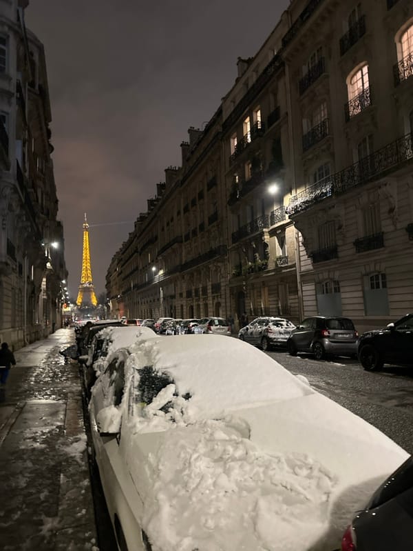 Nighttime Paris street scene captures illuminated Eiffel Tower