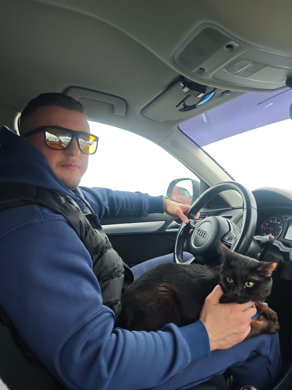 Man holds cat while sitting in car in Chaikovsky, Russia
