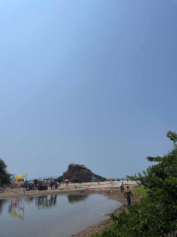 People gather at sandy shoreline in Bhogave, India