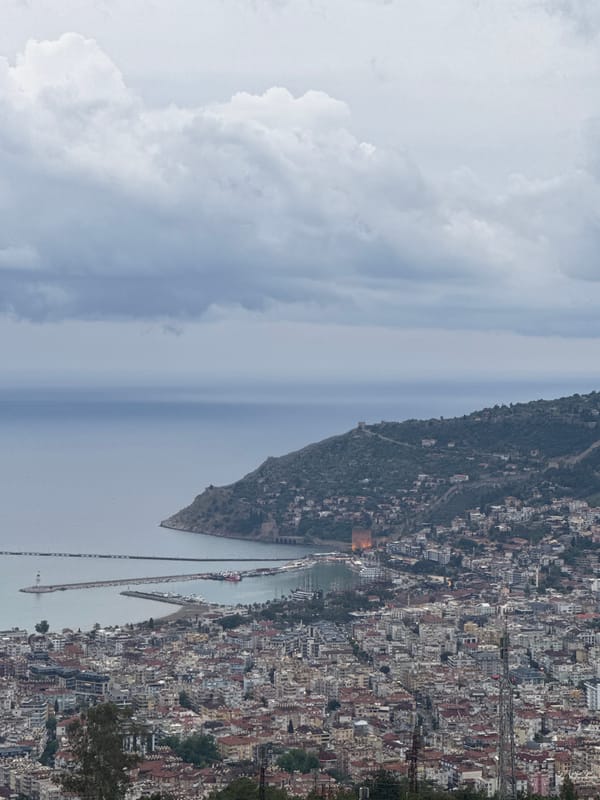 Coastal city observed under cloudy skies with golden lighting