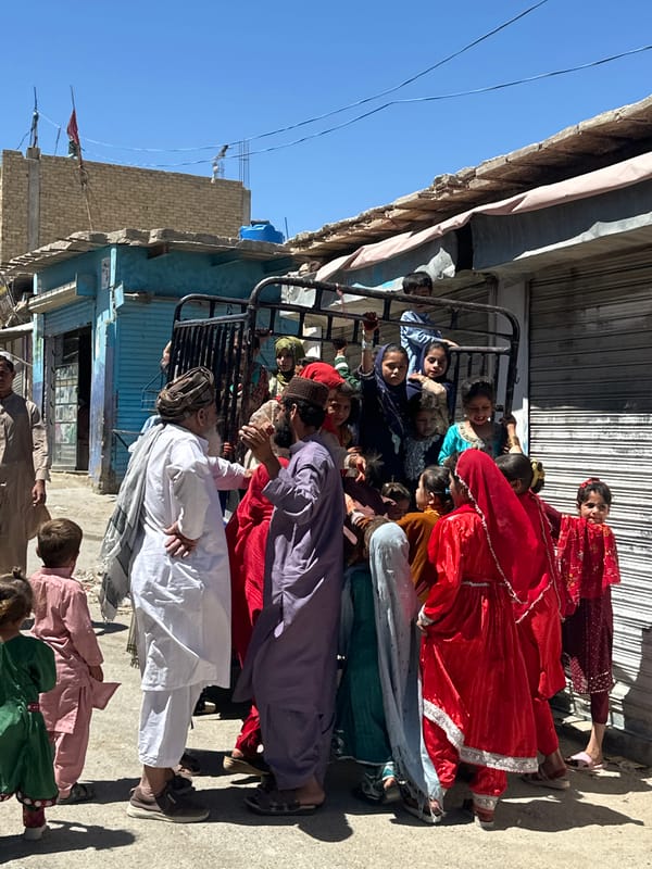 Children gather around makeshift Ferris wheel in Quetta marketplace