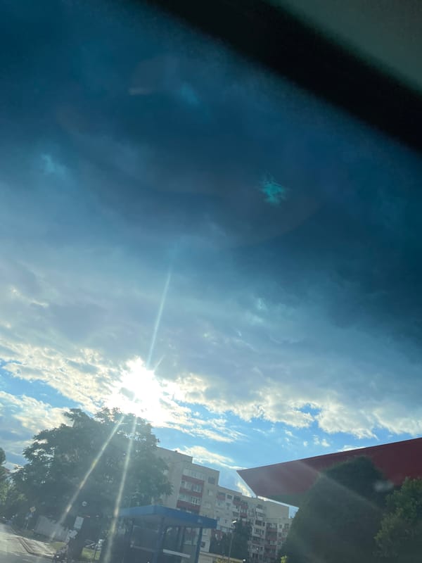 Urban street scene under dramatic cloudy skies with sunlight