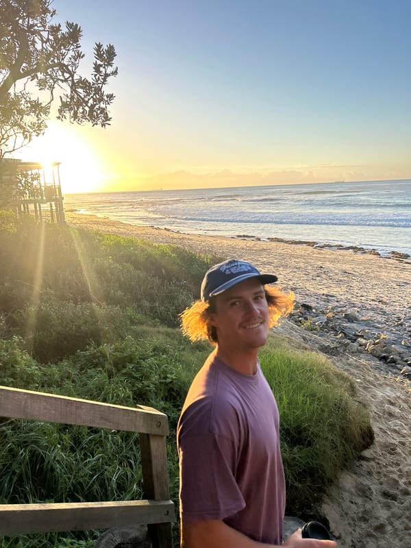 Young man poses at beach dunes during golden hour