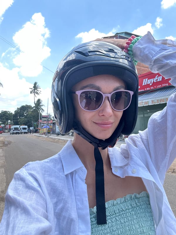 Woman in motorcycle helmet takes selfie in Mũi Né