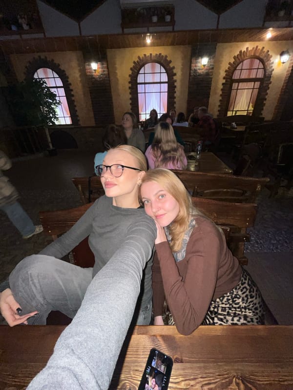 Two women document cafe visit with selfies in Chaikovsky