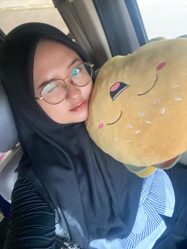 Woman rests with hamburger plush toy in Boro, Indonesia
