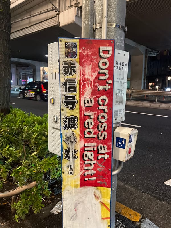Bilingual pedestrian safety sign observed in Minato, Japan