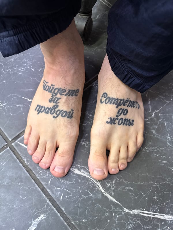 Tattooed feet photographed on marble floor in Moscow
