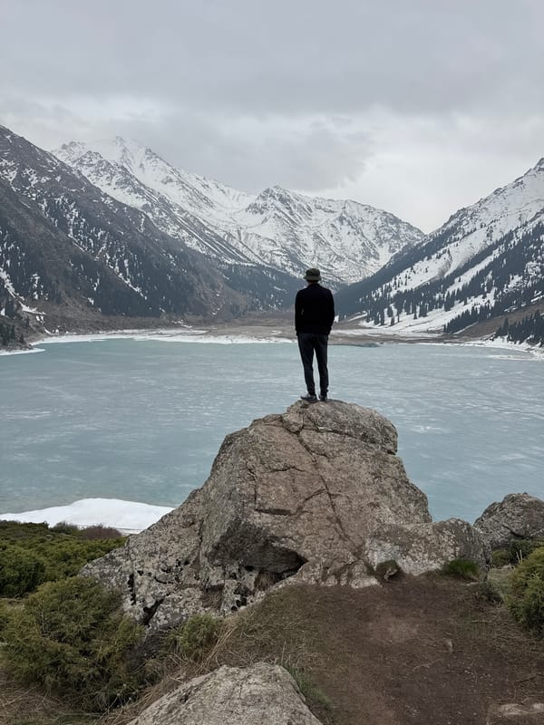 Tourist documents scenic mountain lake visit near Almaty, Kazakhstan