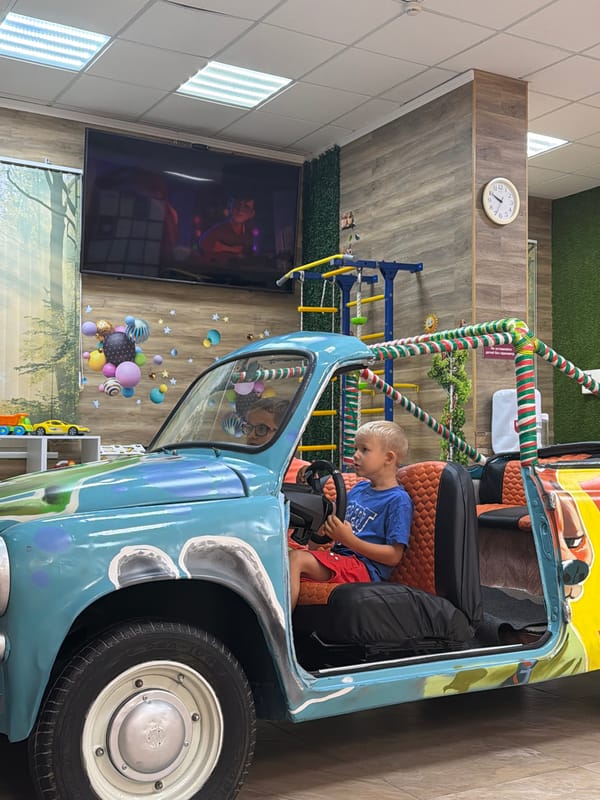 Kid in toy car, waiting area vibes at a Sochi play venue