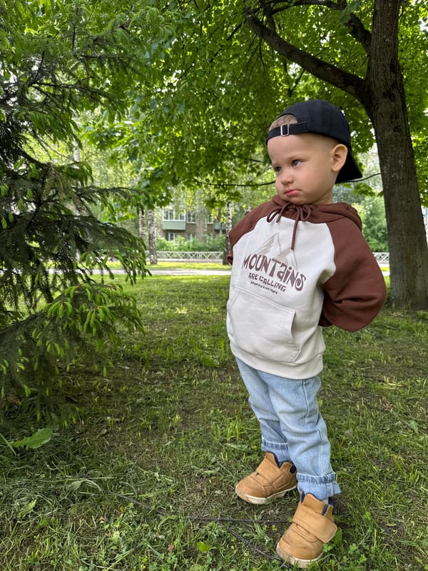 Child finds mushroom in grass during morning outing