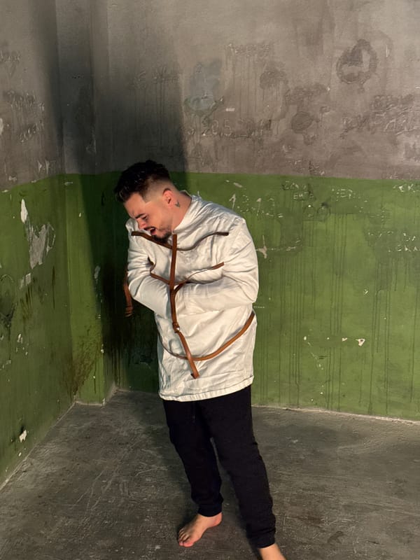 Man in straitjacket filmed in dilapidated Sofia room
