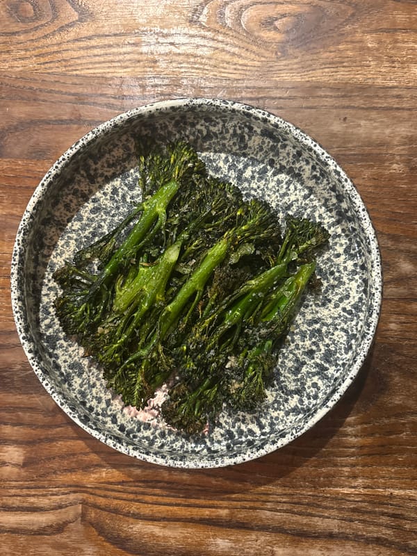Cooked broccolini served on speckled ceramic plate in London