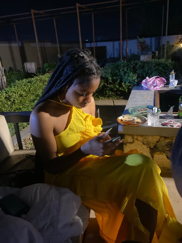 Casual nighttime hangout in Jos, Nigeria, phones out