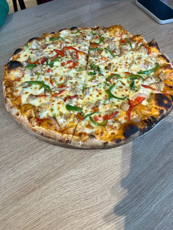Two women share pizza at Abuja restaurant