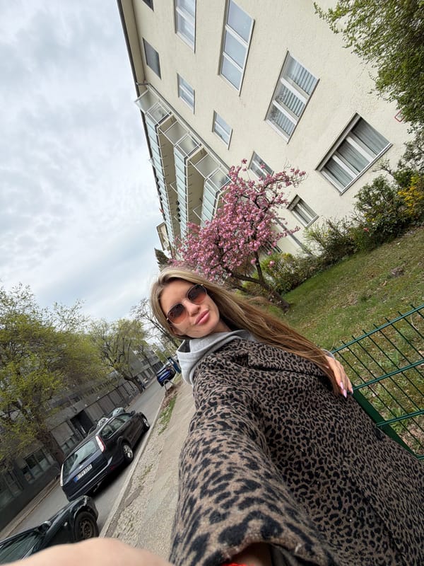 Woman in leopard coat takes selfies on Berlin street