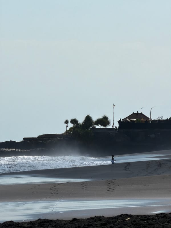 Volcanic beach and palm huts on a quiet Bali morning