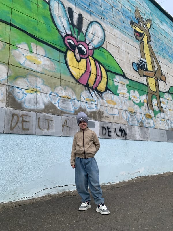 Child poses at cartoon mural in Severodvinsk, Russia