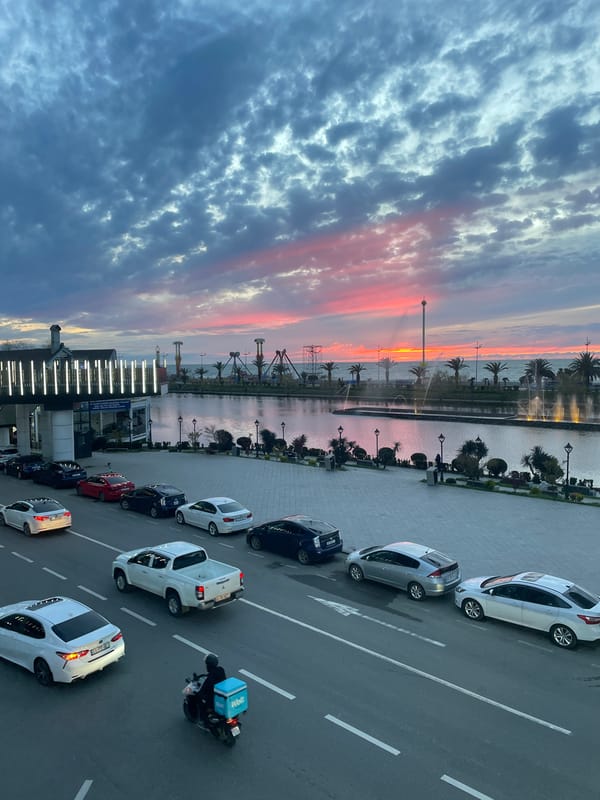Elevated view captures Batumi waterfront street scene with parked cars