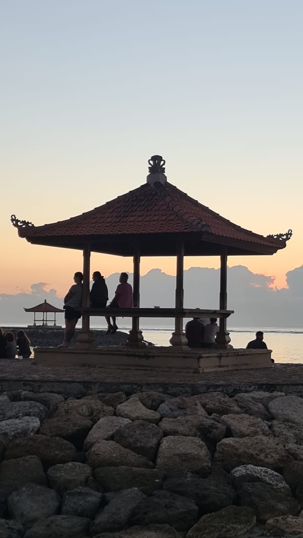 Sanur Beach at golden hour, boats, rocks, and quiet shoreline moments
