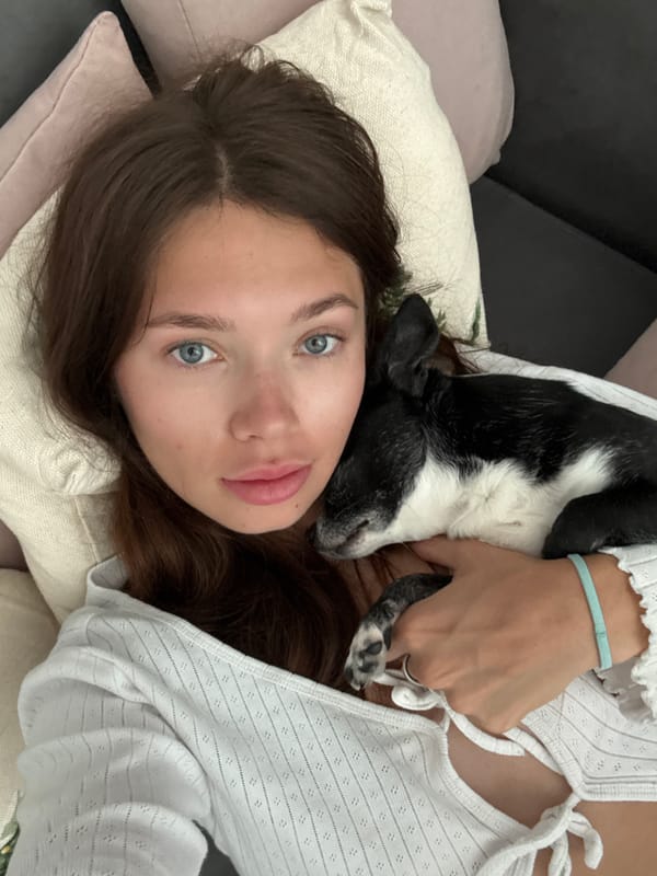 Woman relaxes with black and white dog on sofa