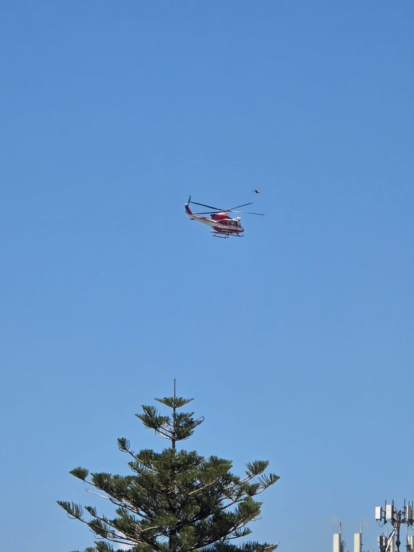 Red and white helicopter over Salerno on a clear morning