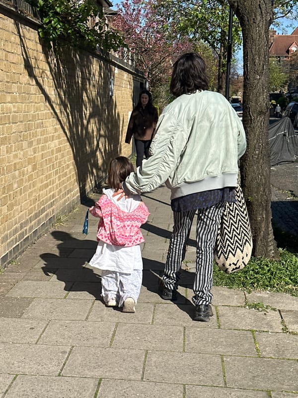 Person walks London streets, takes selfie on sunny afternoon