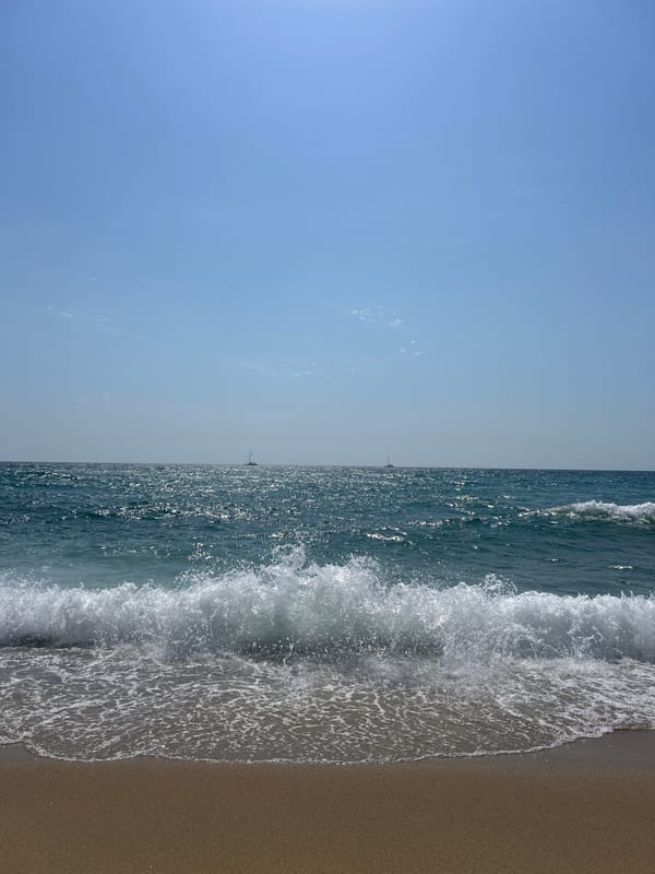 Barcelona beach morning: waves, sailboats, and a passing helicopter