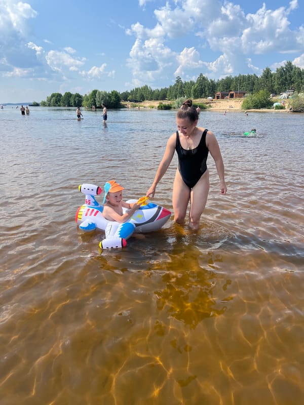 Sunny summer day at a Russian lakeside beach with inflatable toys